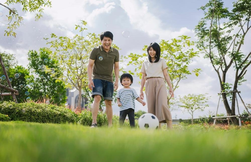 Asian,Parents,And,Little,Boy,Playing,Soccer,In,The,Park